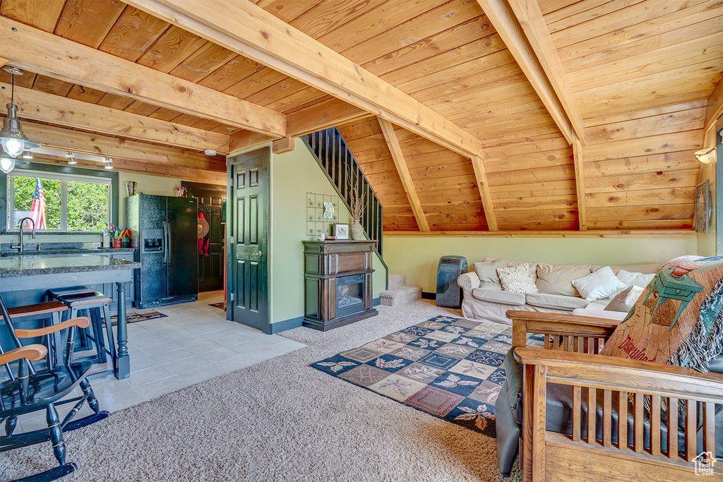 Living area featuring a wooden ceiling with exposed beams, light colored carpet, and light tile patterned floors