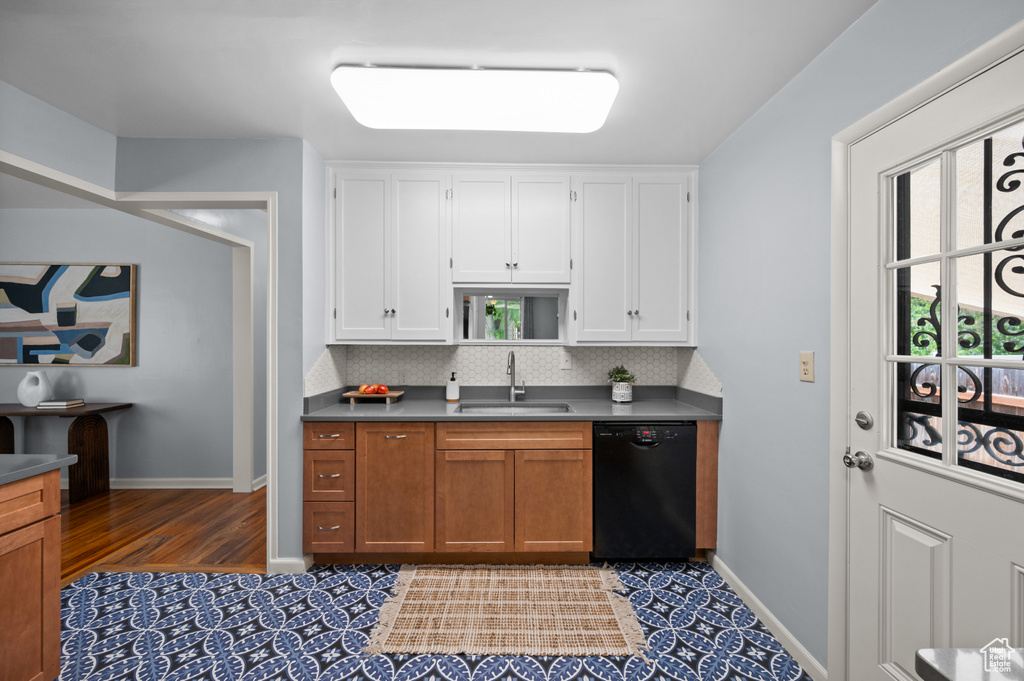 Kitchen with dishwasher, white cabinets, decorative backsplash, and dark countertops