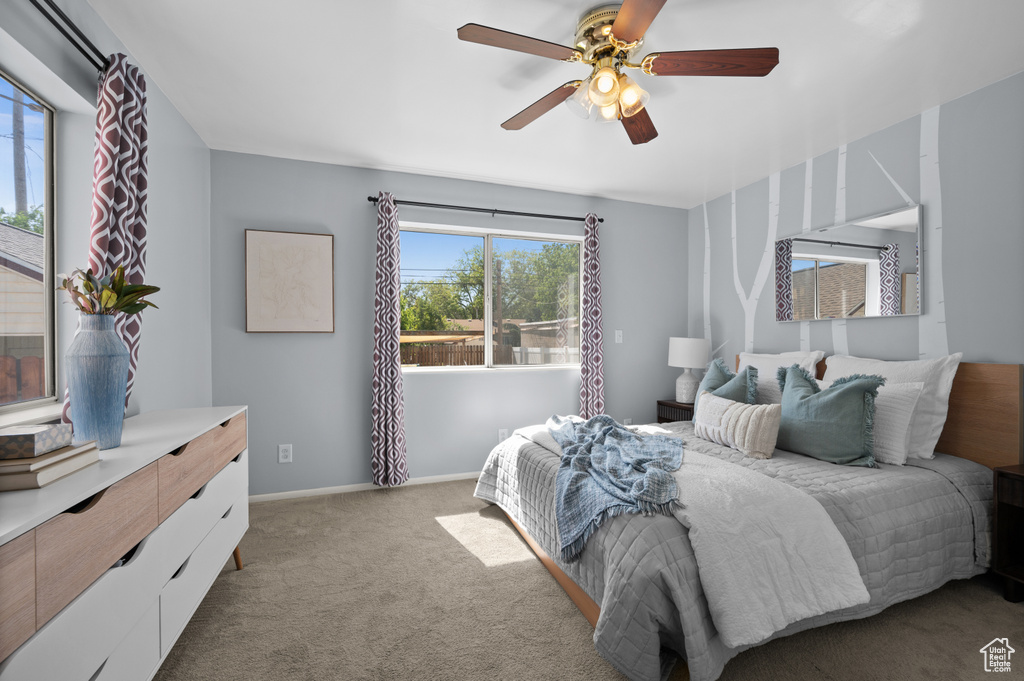 Bedroom with multiple windows, carpet, and a ceiling fan