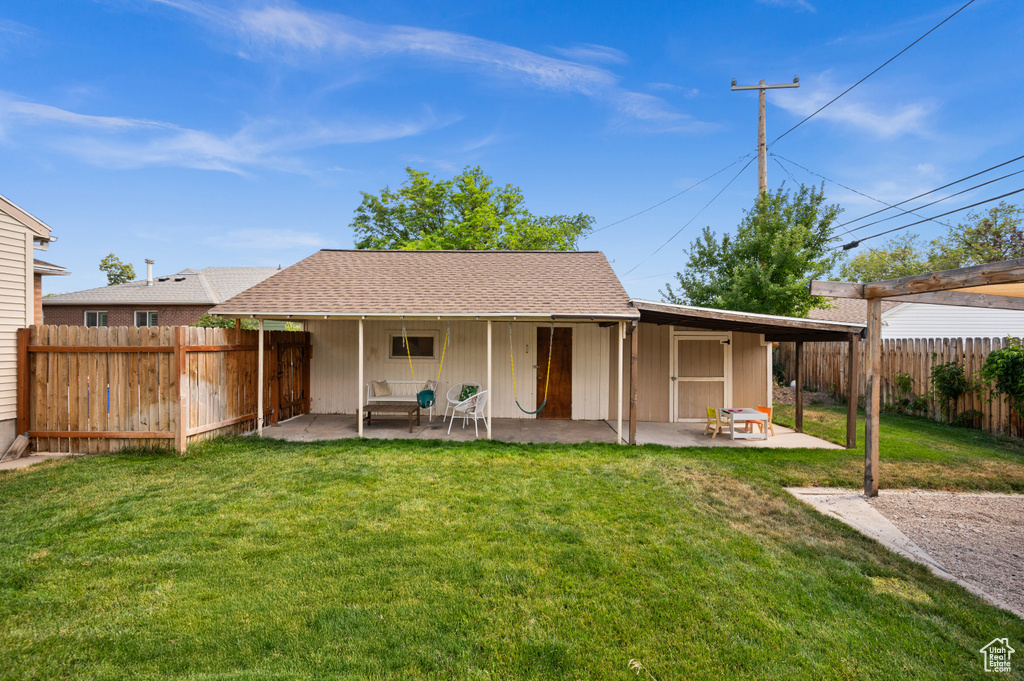 Rear view of house with a patio, a fenced backyard, and roof with shingles