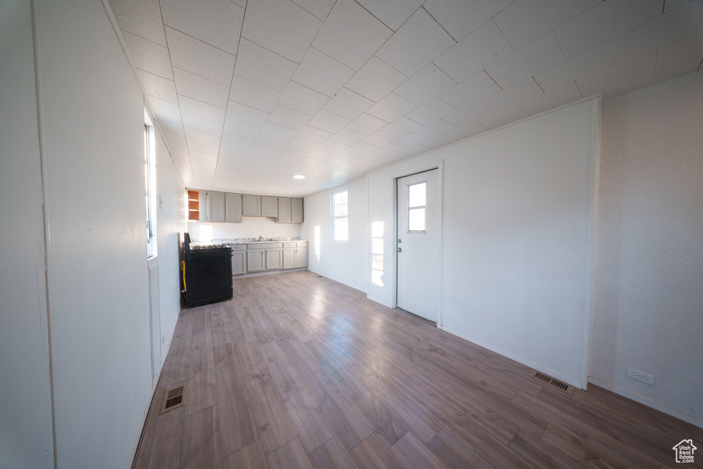 Kitchen featuring light countertops, wood finished floors, and open shelves