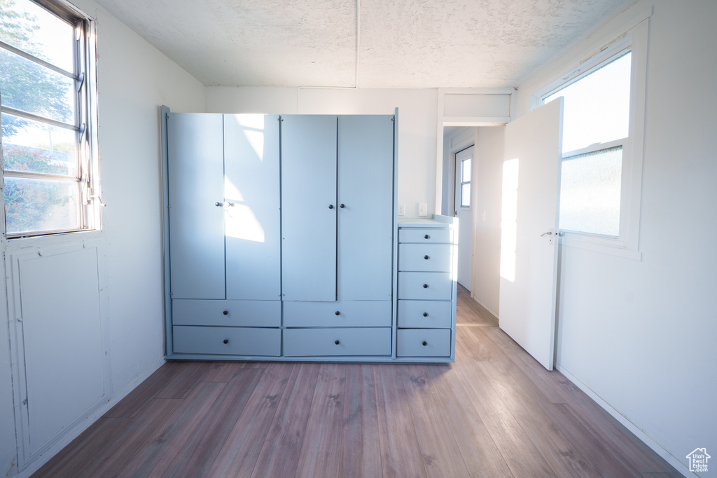 Unfurnished bedroom featuring wood finished floors and a textured ceiling