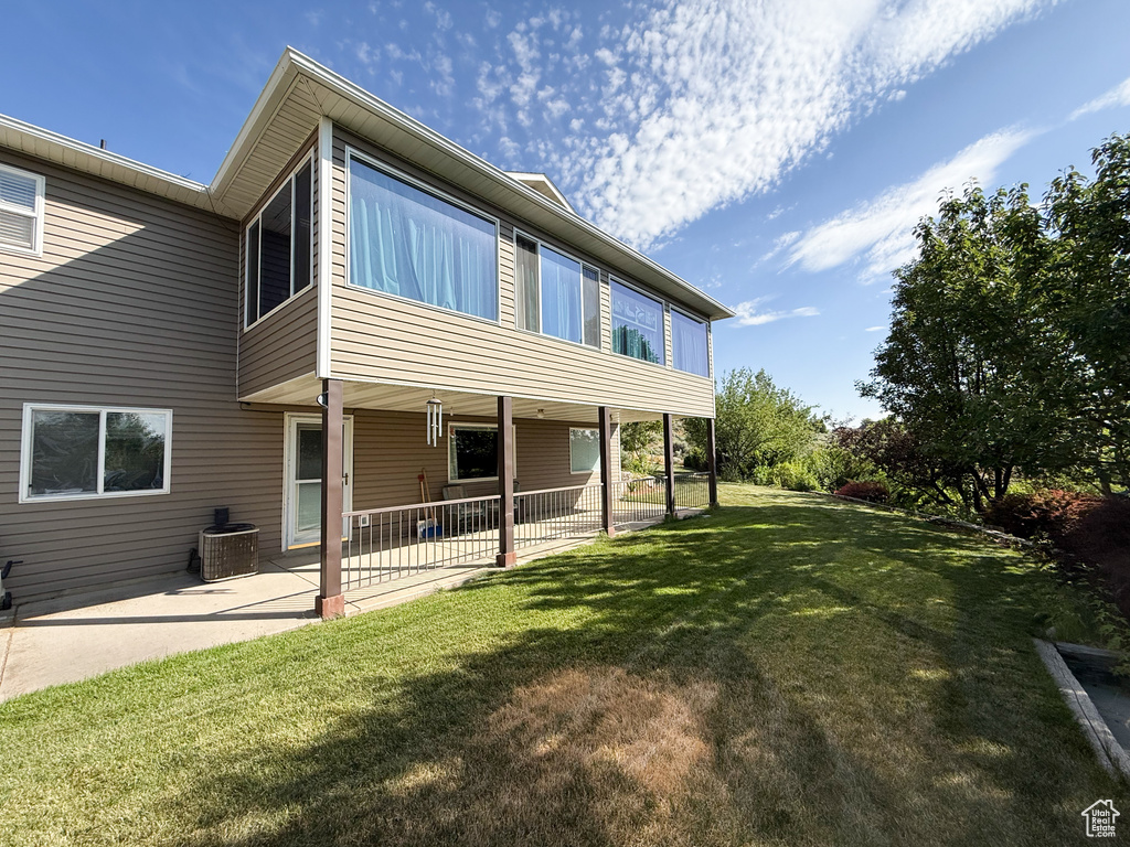 Rear view of property with a patio and a lawn