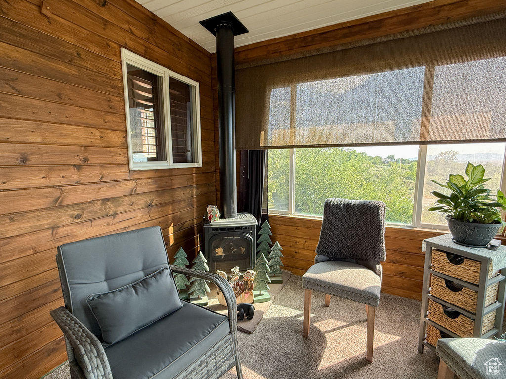Sunroom / solarium with a wood stove and healthy amount of natural light