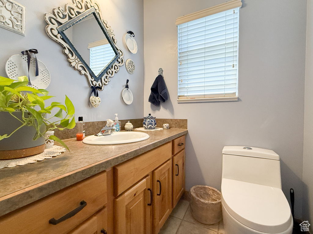Half bath with vanity and tile patterned flooring