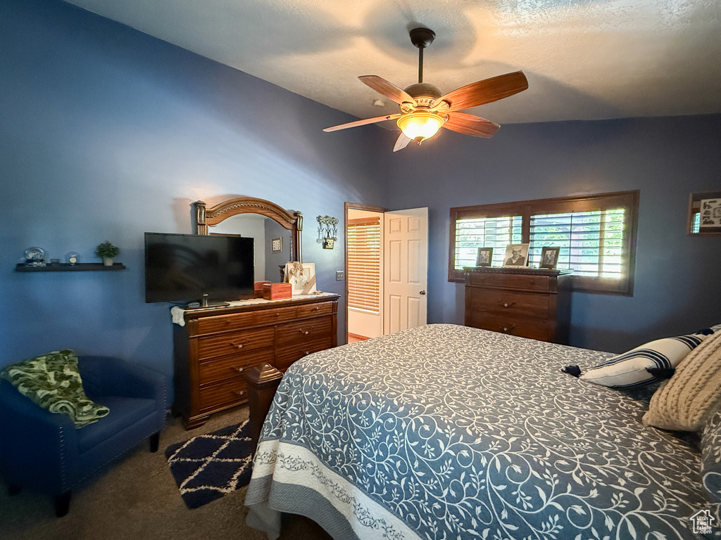 Bedroom featuring carpet flooring, ceiling fan, and vaulted ceiling