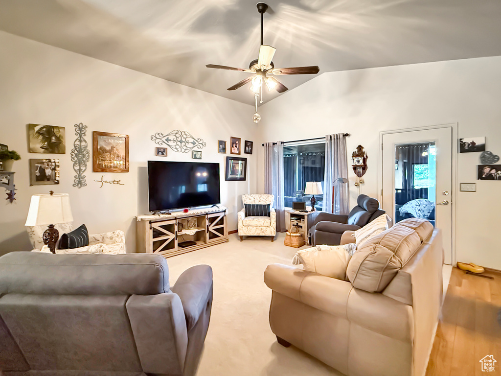 Living area with ceiling fan, vaulted ceiling, and wood finished floors