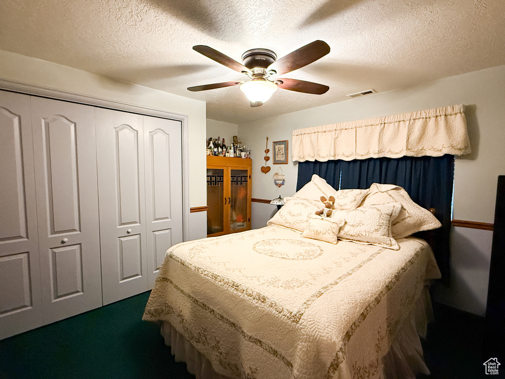 Bedroom featuring a closet, ceiling fan, and a textured ceiling
