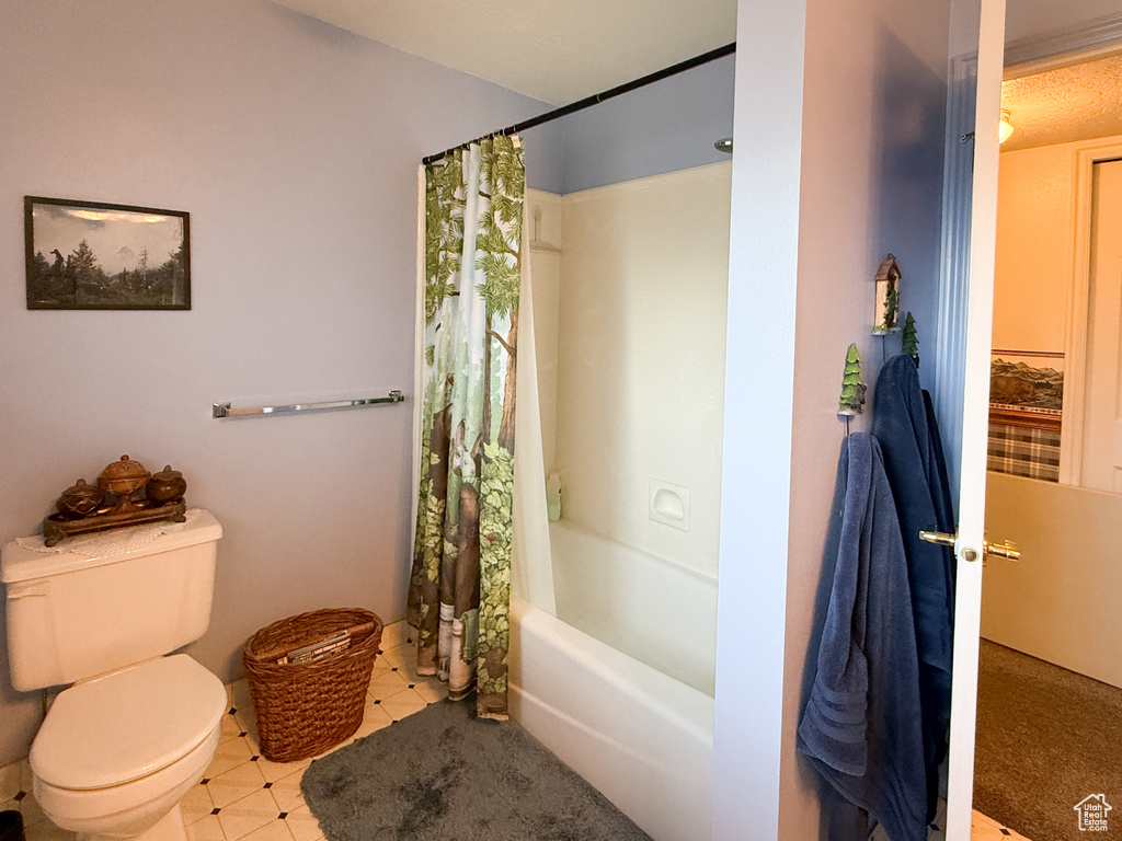 Full bath featuring toilet and shower / bathtub combination with curtain