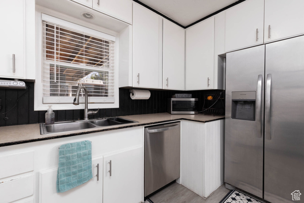Kitchen with appliances with stainless steel finishes, white cabinetry, and dark countertops