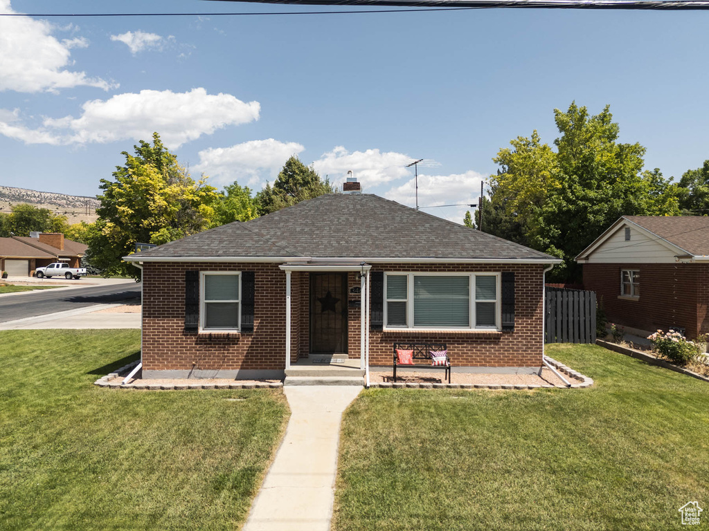 Bungalow-style home featuring brick siding and a shingled roof
