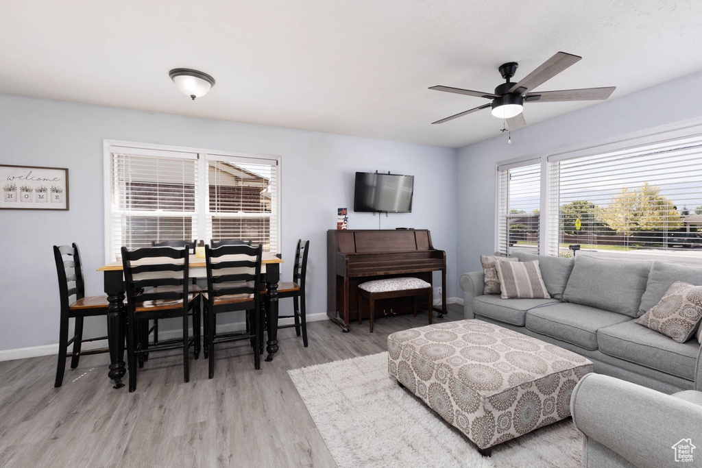 Living room with light wood-type flooring and a ceiling fan
