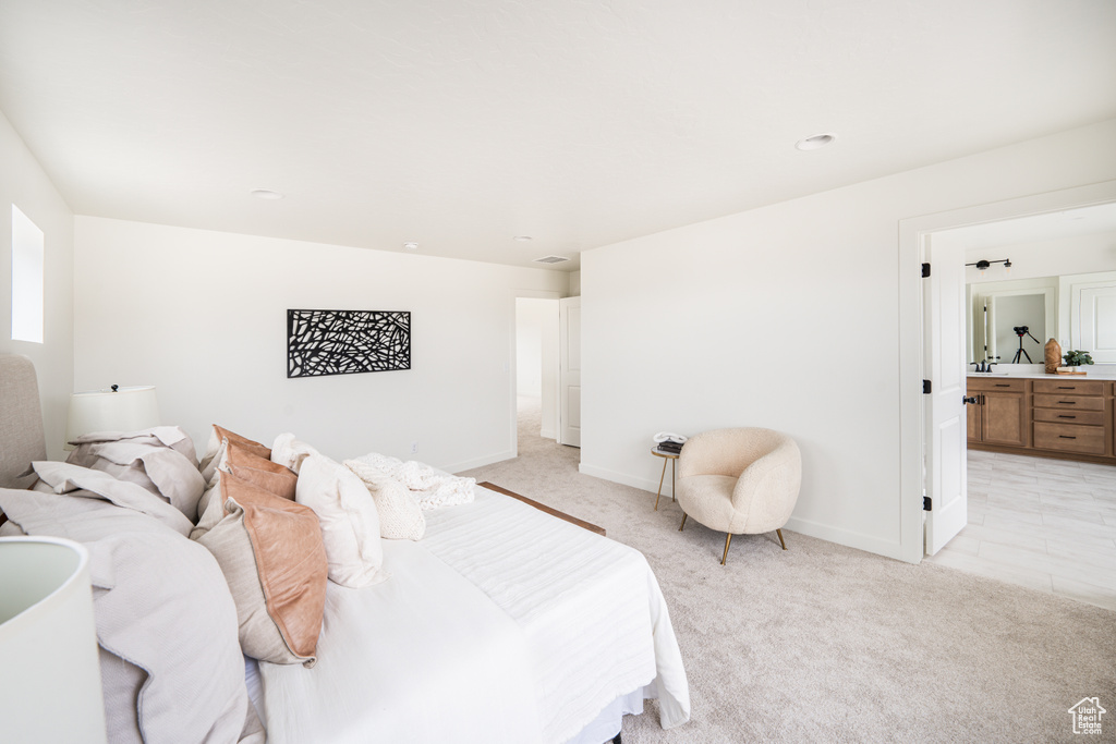Bedroom featuring light carpet and connected bathroom