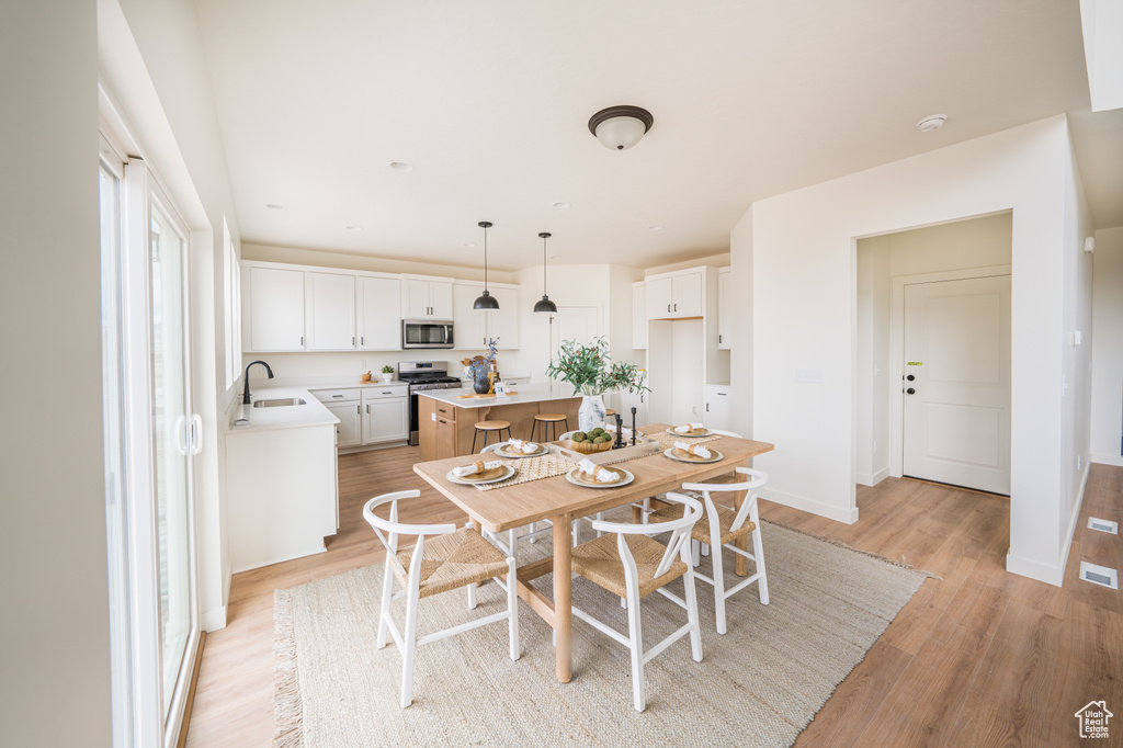Dining area with light wood-style flooring and baseboards