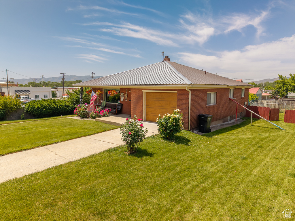 View of front of home with a garage, a metal roof, a mountain view, and brick siding
