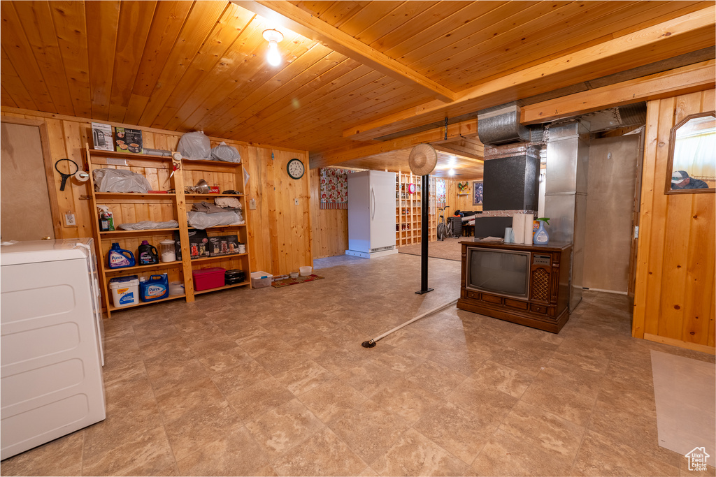 Living room with wooden walls, tile patterned floors, and wood ceiling