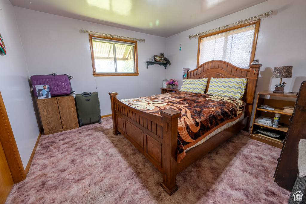 Bedroom with light colored carpet and baseboards