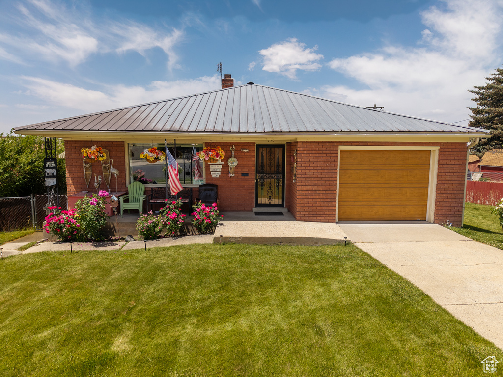 View of front of property with a garage, brick siding, covered porch, concrete driveway, and a chimney