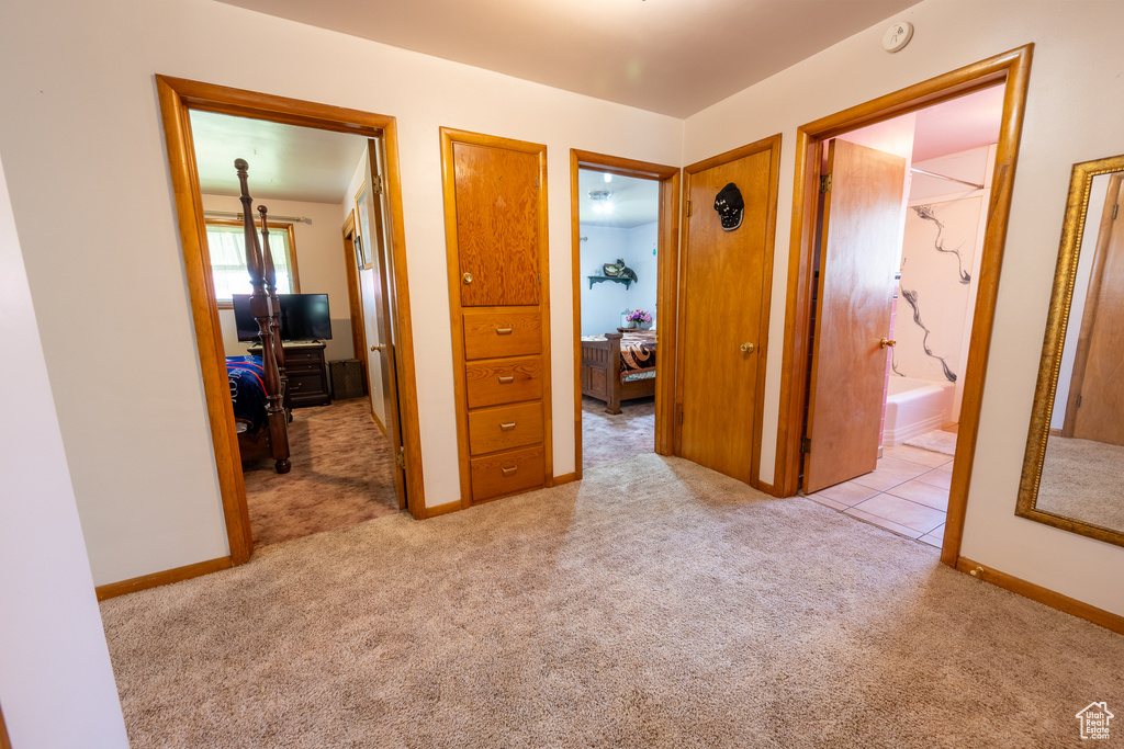 Corridor featuring light carpet and baseboards