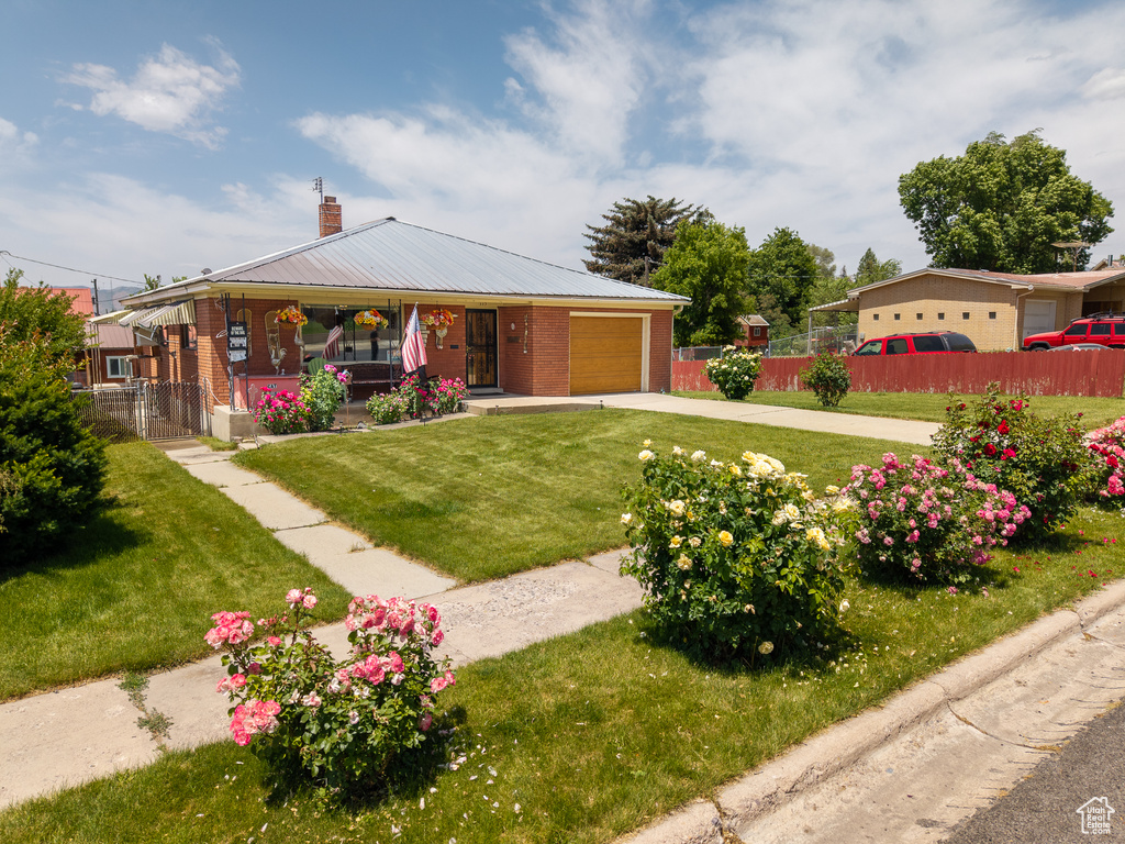 View of front of house featuring an attached garage, a porch, concrete driveway, brick siding, and a chimney