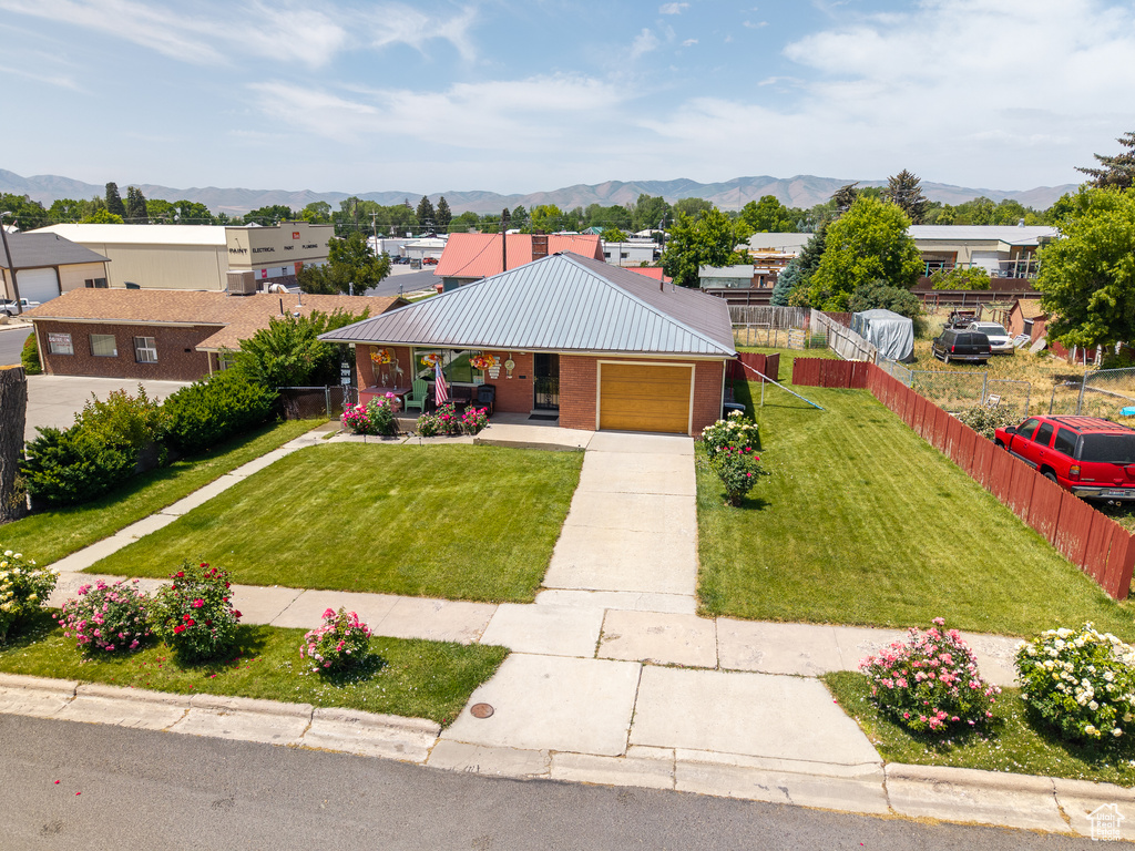 Ranch-style home with a mountain view, brick siding, driveway, and a porch