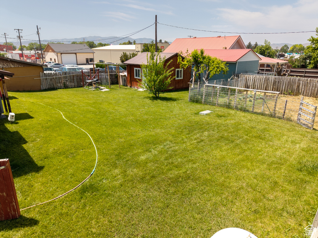 Fenced yard featuring a garden and a mountain view