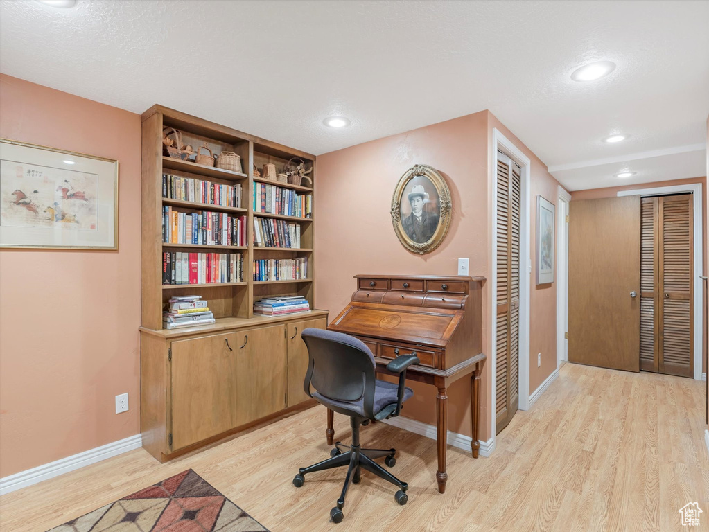 Office area with light wood-style flooring and recessed lighting