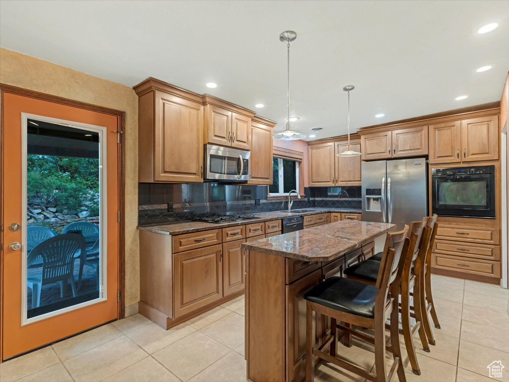 Kitchen featuring black appliances, light tile patterned floors, dark stone countertops, decorative backsplash, and recessed lighting