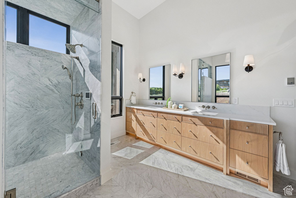 Full bath with a marble finish shower, double vanity, and marble finish floors