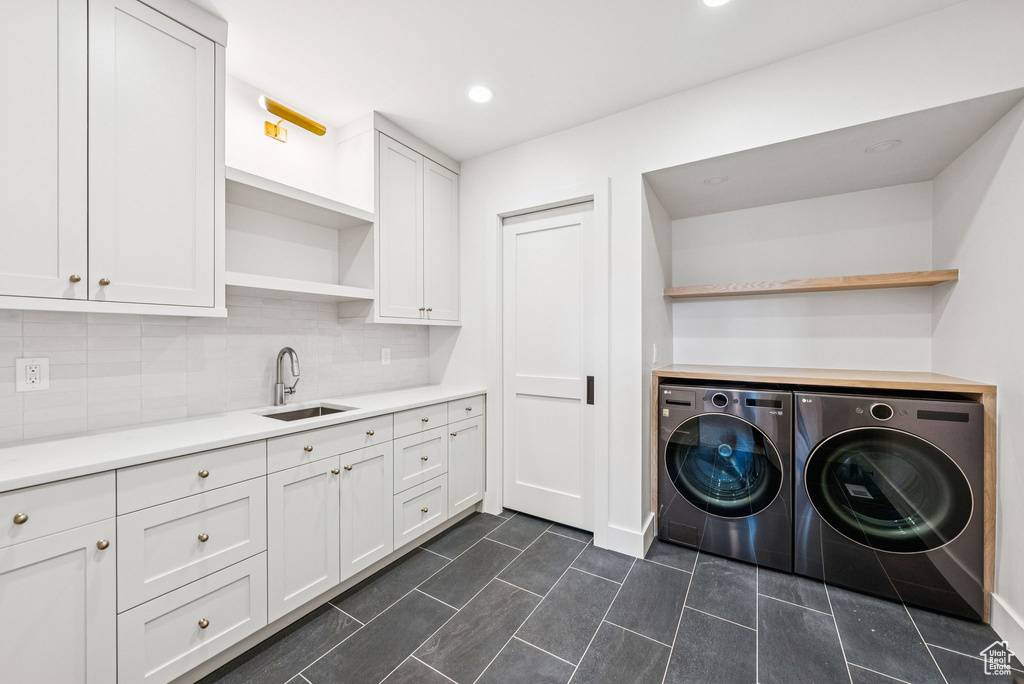 Washroom with washer and dryer, dark tile patterned floors, cabinet space, and recessed lighting