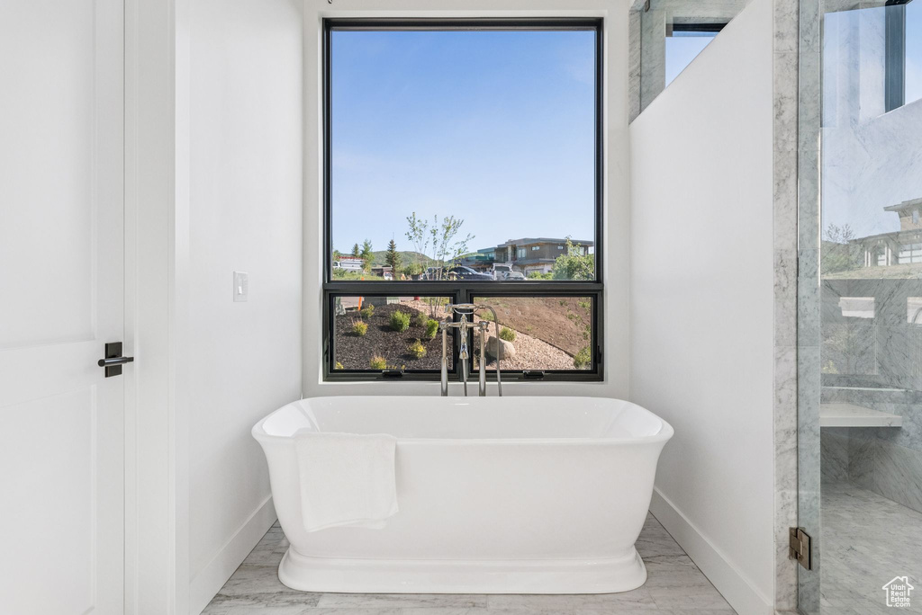 Full bathroom featuring a freestanding tub and a shower stall