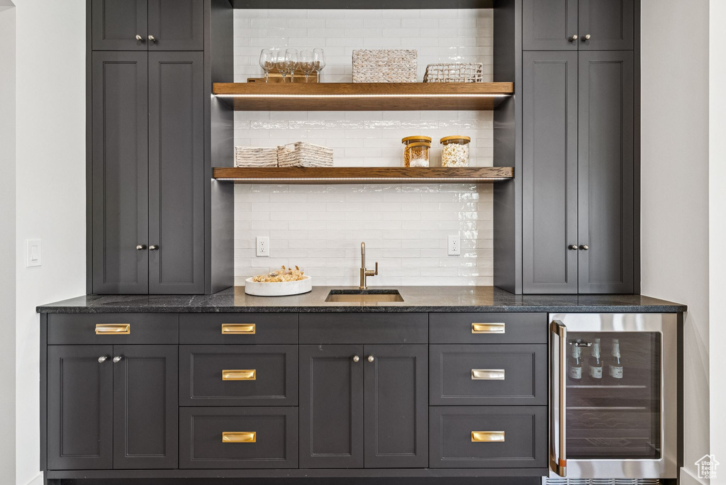 Indoor wet bar with beverage cooler and tasteful backsplash