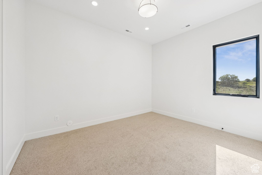 Carpeted spare room featuring baseboards and recessed lighting