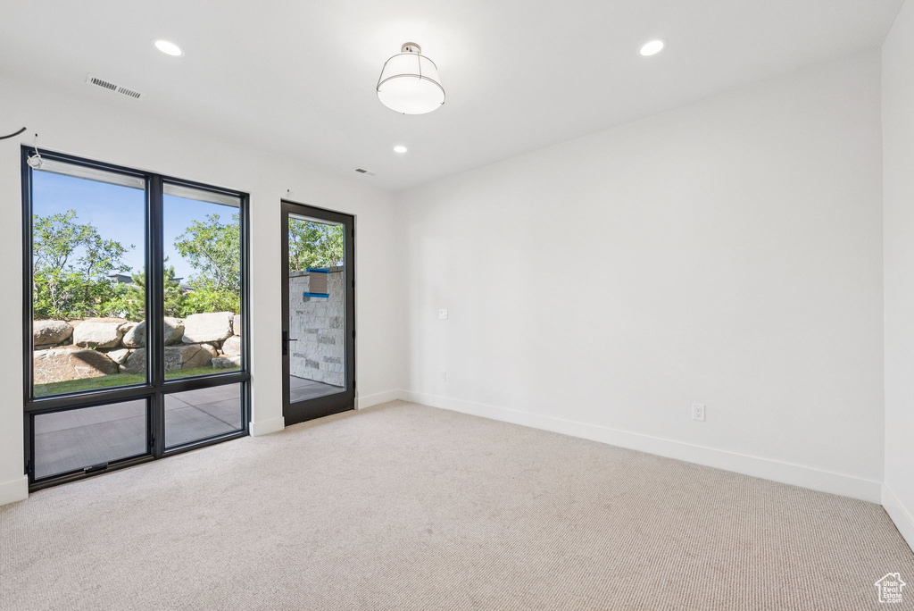 Carpeted empty room with recessed lighting