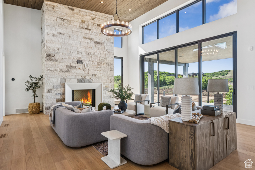 Living room with wooden ceiling, recessed lighting, wood finished floors, a high ceiling, and a chandelier