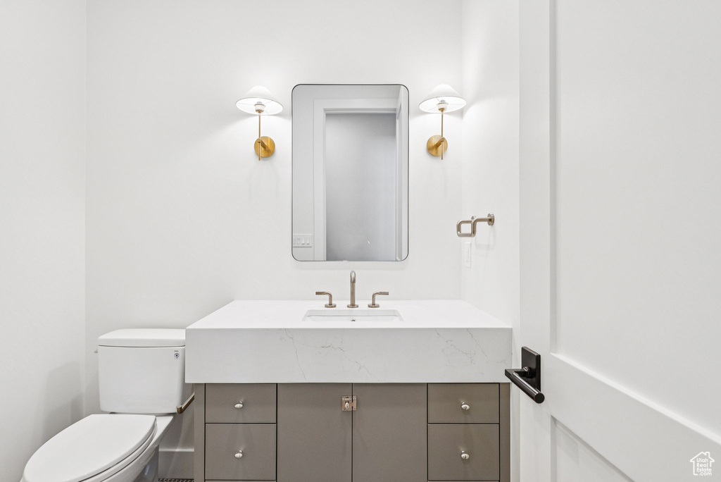 Half bathroom featuring vanity and toilet