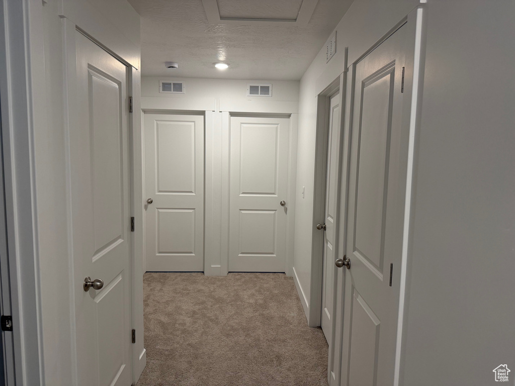 Hallway with carpet flooring and attic access