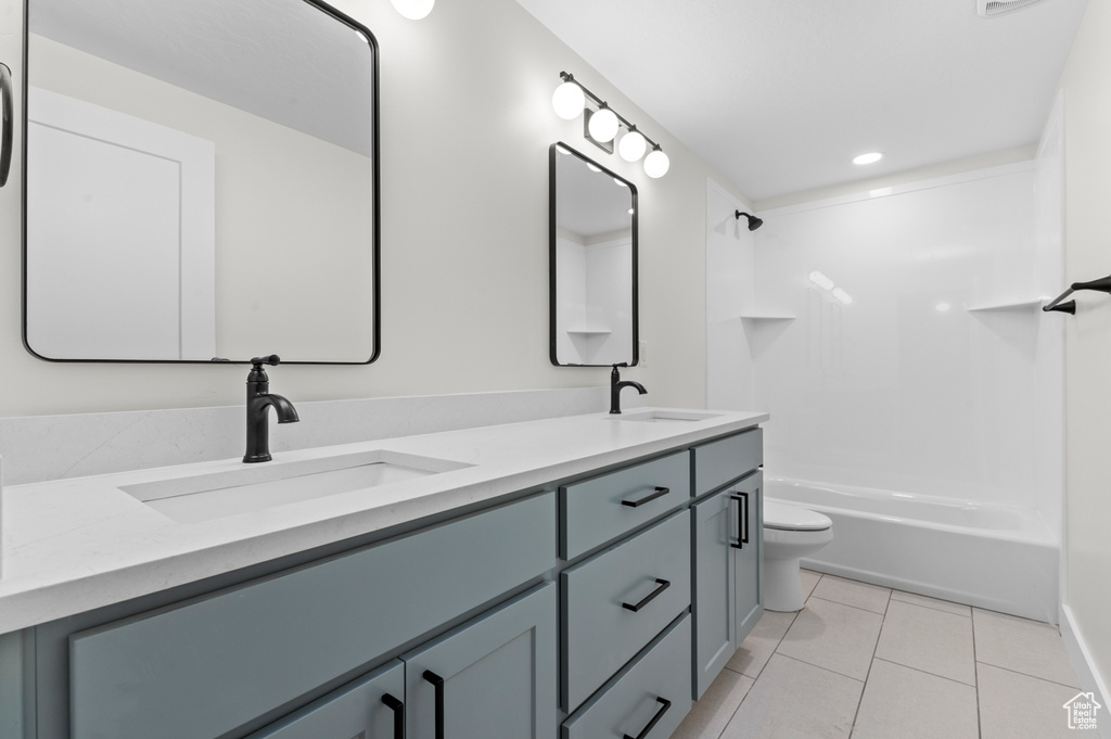 Full bath featuring double vanity, tile patterned flooring, bathing tub / shower combination, and recessed lighting