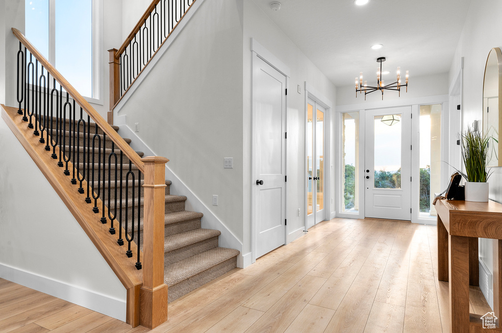 Foyer entrance with a chandelier, stairway, light wood-style flooring, and recessed lighting