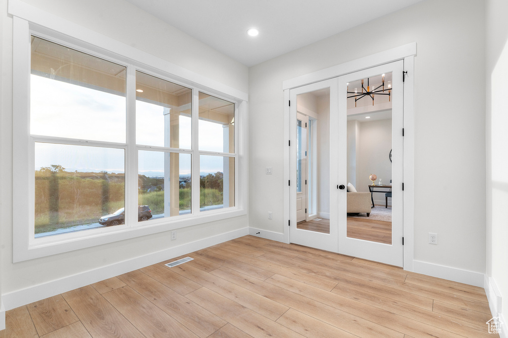 Spare room featuring light wood-style flooring, recessed lighting, and french doors