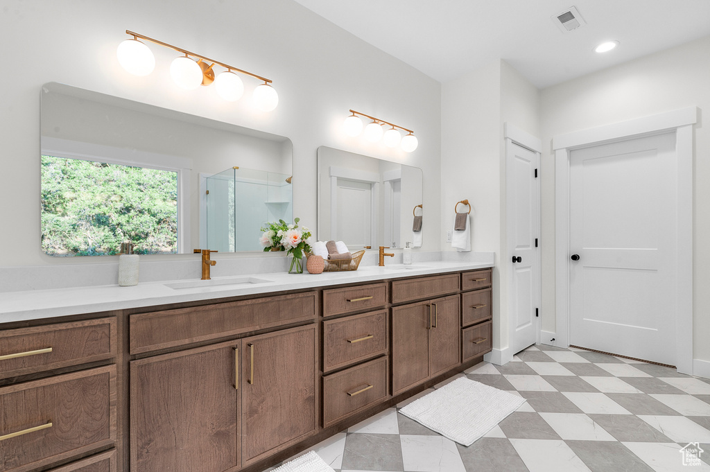 Full bath featuring double vanity, a shower stall, and tile patterned floors