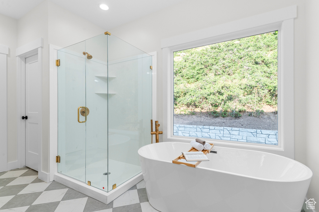 Full bathroom featuring a stall shower, a freestanding tub, tile patterned floors, and recessed lighting