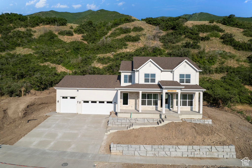 View of front of home featuring driveway, an attached garage, and a mountain view