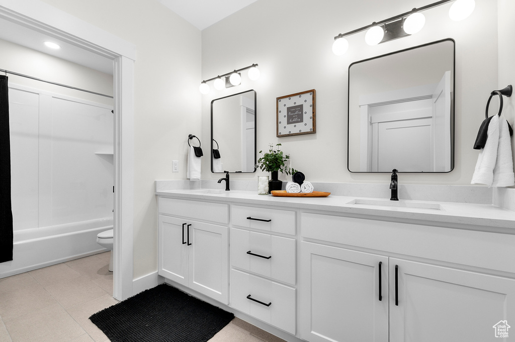 Bathroom with double vanity and bathing tub / shower combination