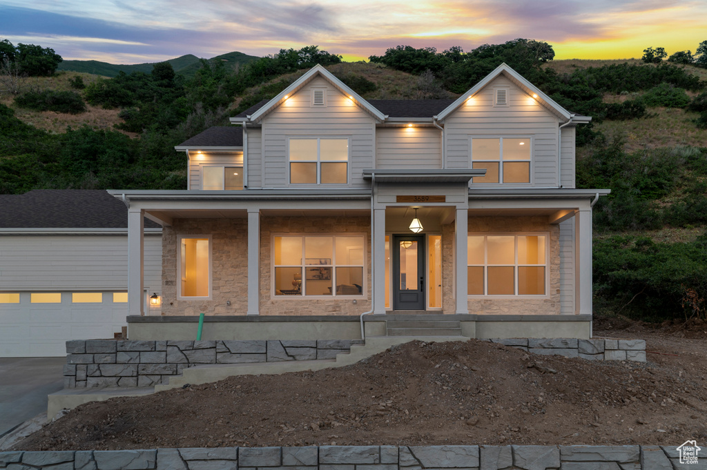 View of front of home with covered porch, driveway, and an outdoor structure