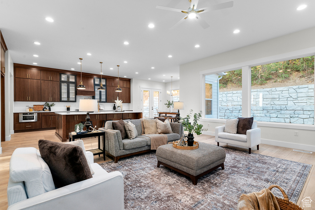Living room with light wood-type flooring, recessed lighting, and a ceiling fan
