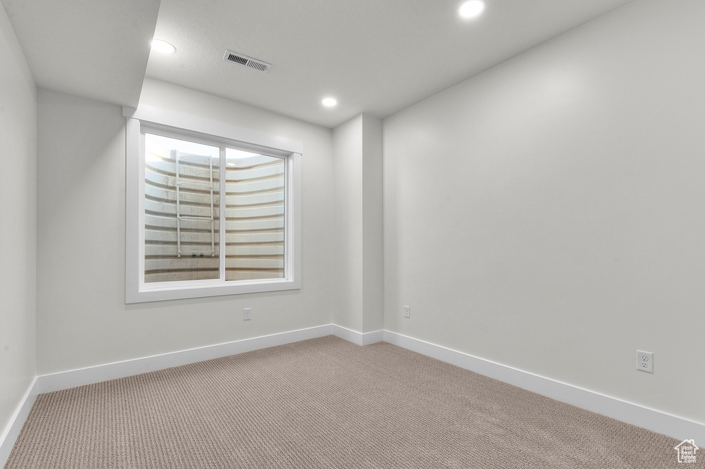 Carpeted empty room featuring recessed lighting and baseboards
