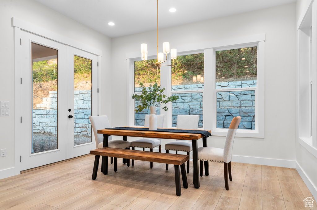 Dining space featuring french doors, light wood finished floors, a chandelier, and recessed lighting