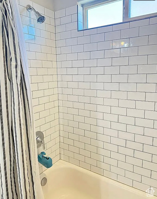 Bathroom featuring shower / bathtub combination with curtain