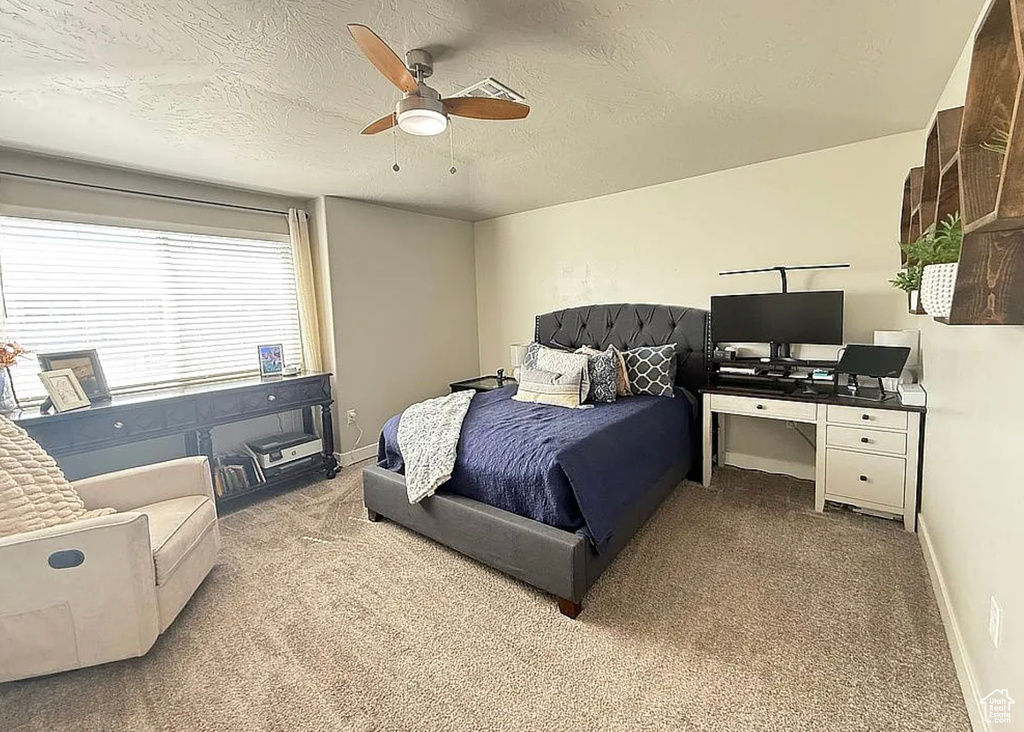 Bedroom featuring carpet, ceiling fan, and a textured ceiling